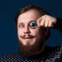 Valerii Karpov, the engineer who replies, holding a lens to his eye